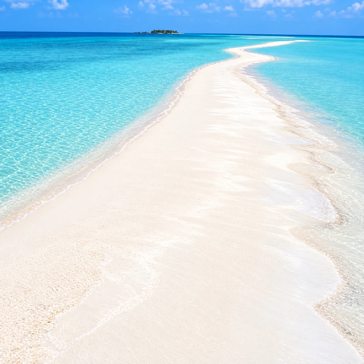 A winding white sandbank surrounded by clear turquoise lagoon water